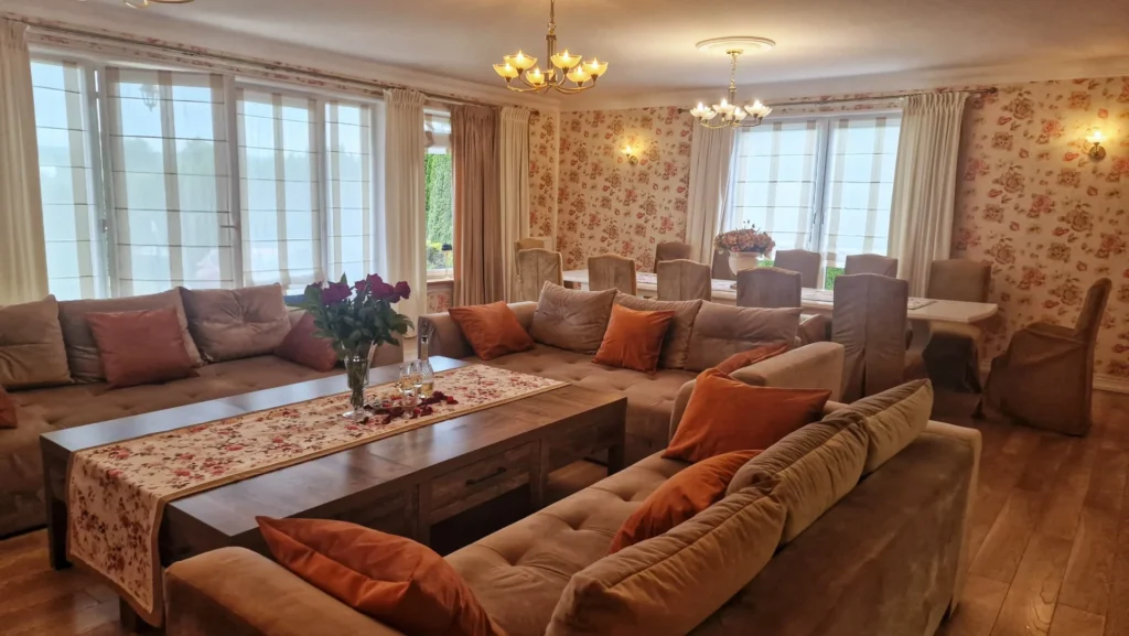 Salon 90 m² – 3 sofy, 75″ Smart TV, kino domowe, stół dla 12 osób, kominek i zasłony sterowane pilotem.